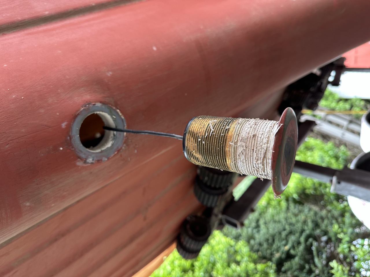 Old depth transducer removed from the hull exterior with the empty thruhull opening visible beside it