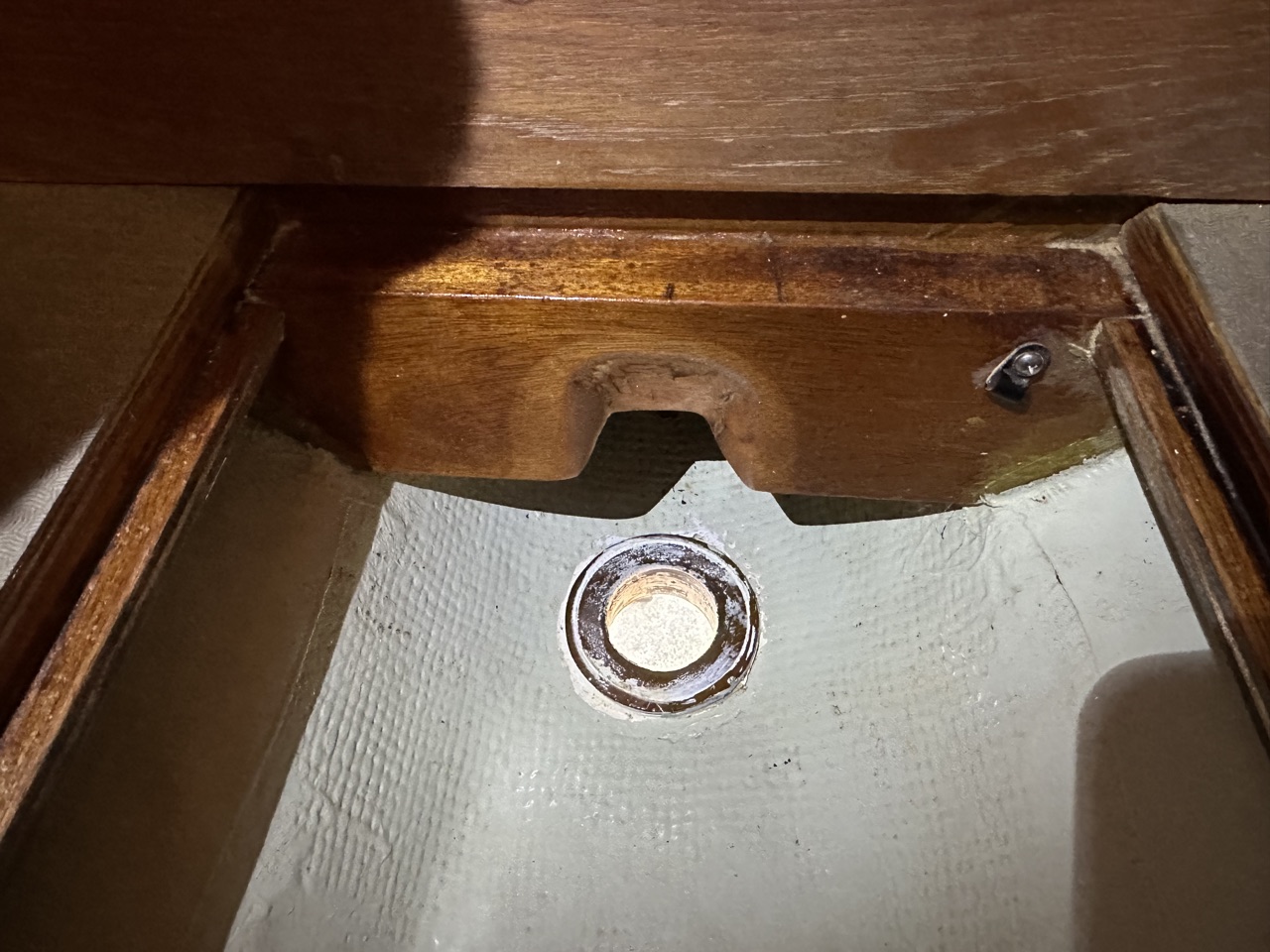 Interior bilge view showing the thruhull opening with a notched wooden stringer trimmed for transducer clearance