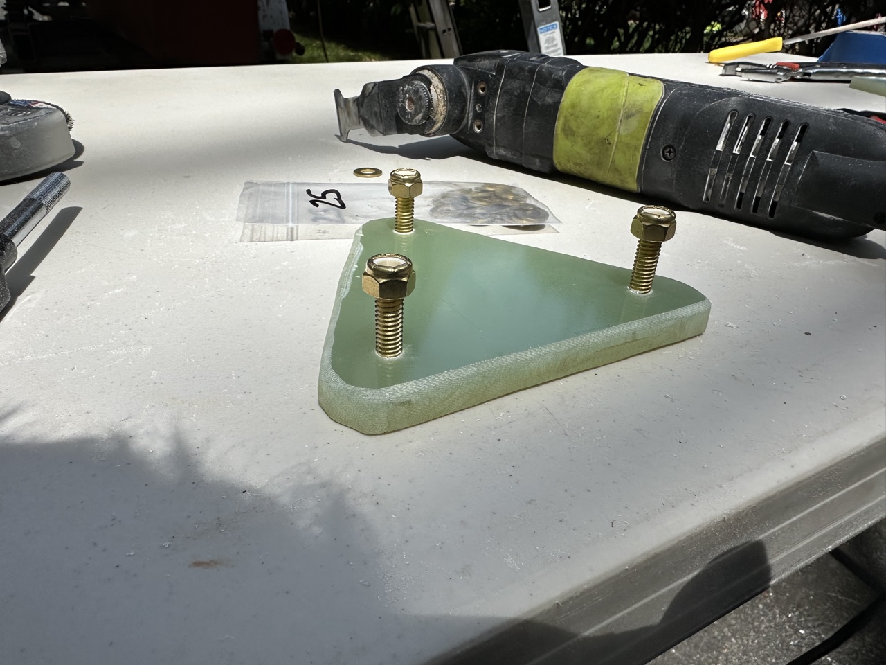 Custom triangular fiberglass backing plate with brass studs, made for the thruhull installations