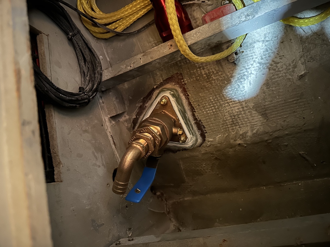 New Groco bronze water intake thruhull installed through the hull with blue-handled seacock