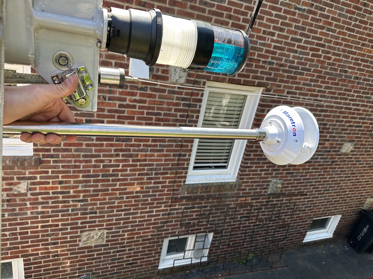 WSO200 on its bent stainless pole being held up to the masthead for positioning