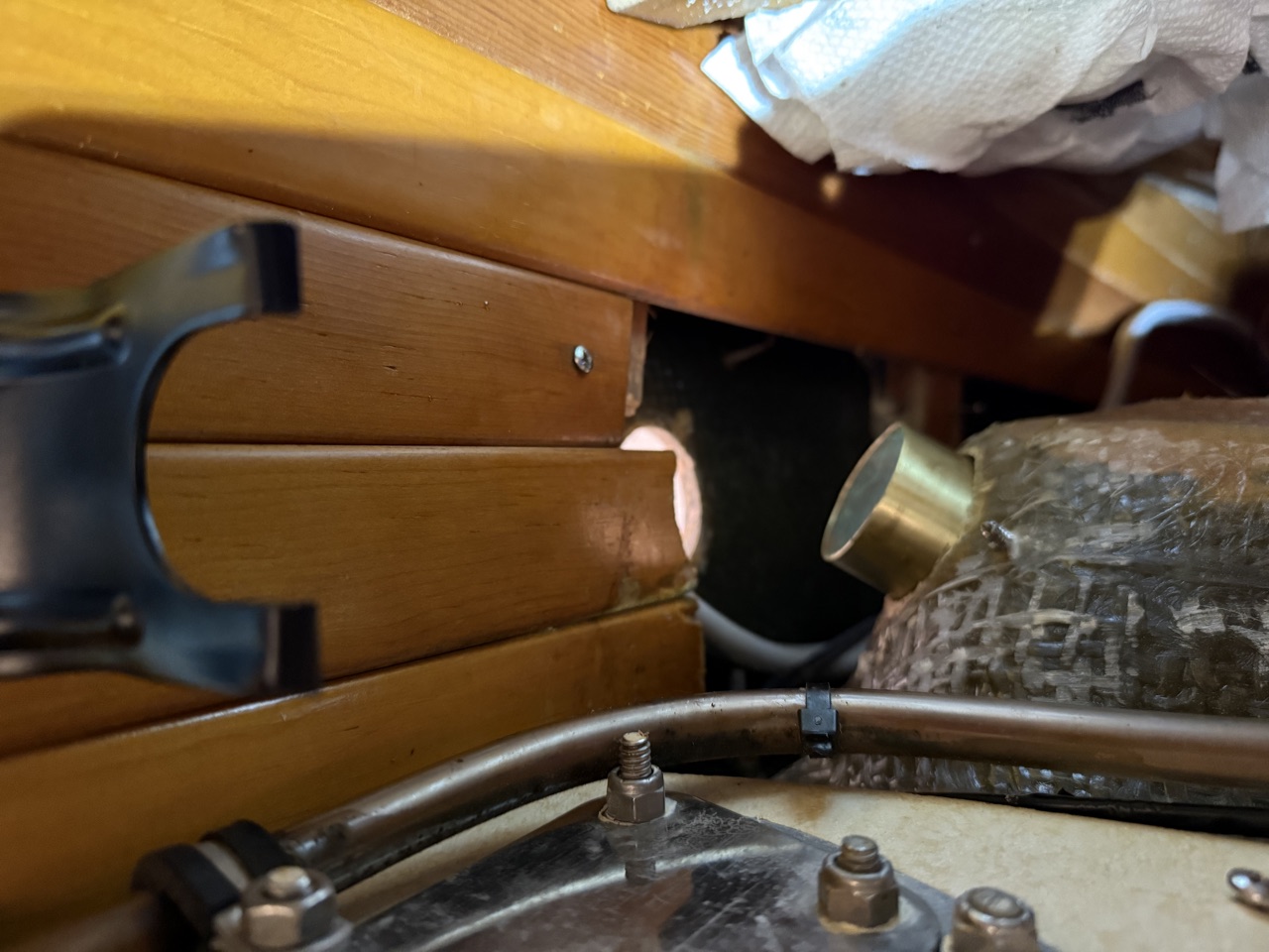 Brass scupper connector after being cut shorter, showing the clean cut end and improved downward angle