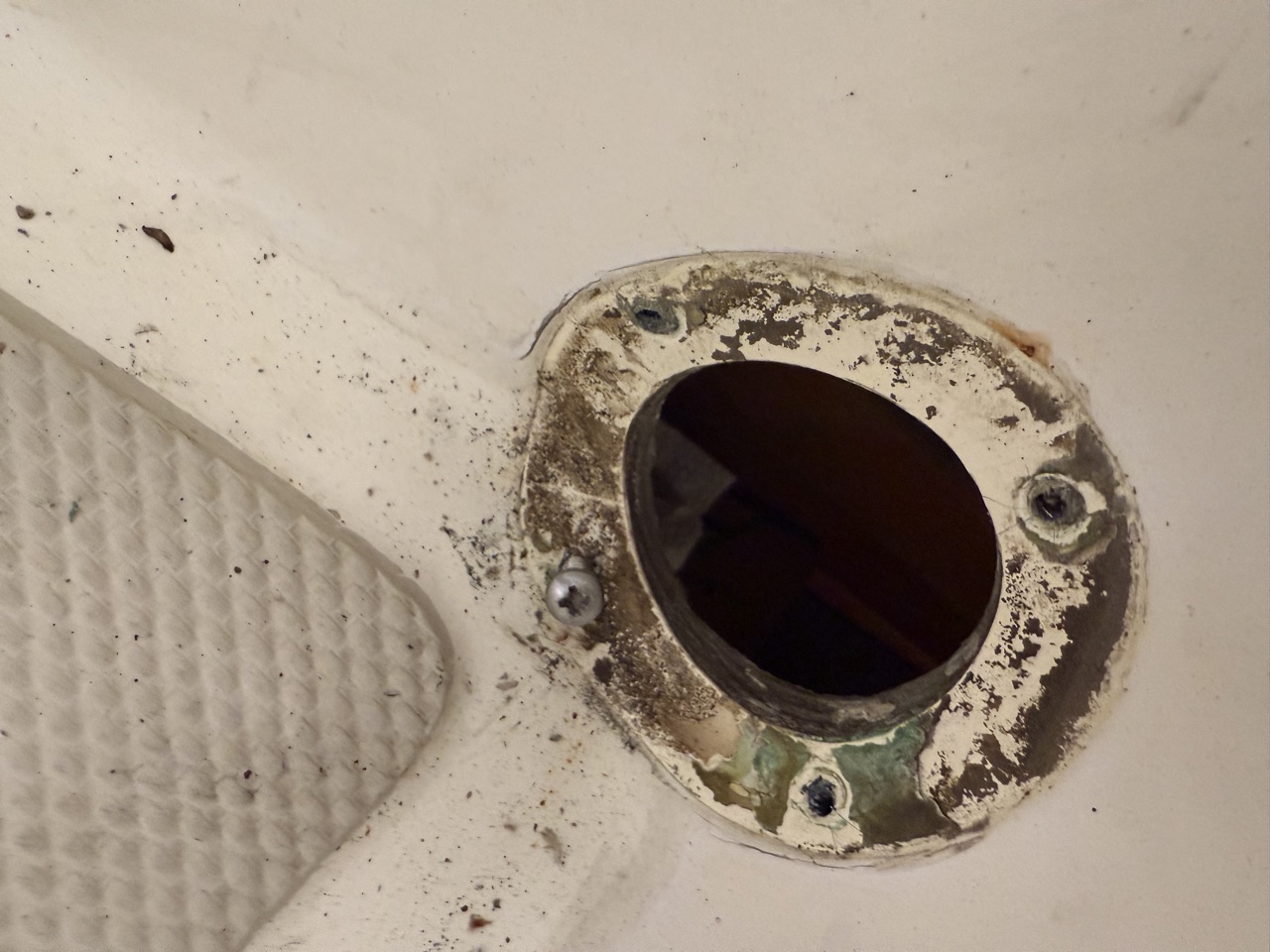 Foredeck scupper opening on Queen of Hearts with the old fitting removed, showing the corroded sealant ring