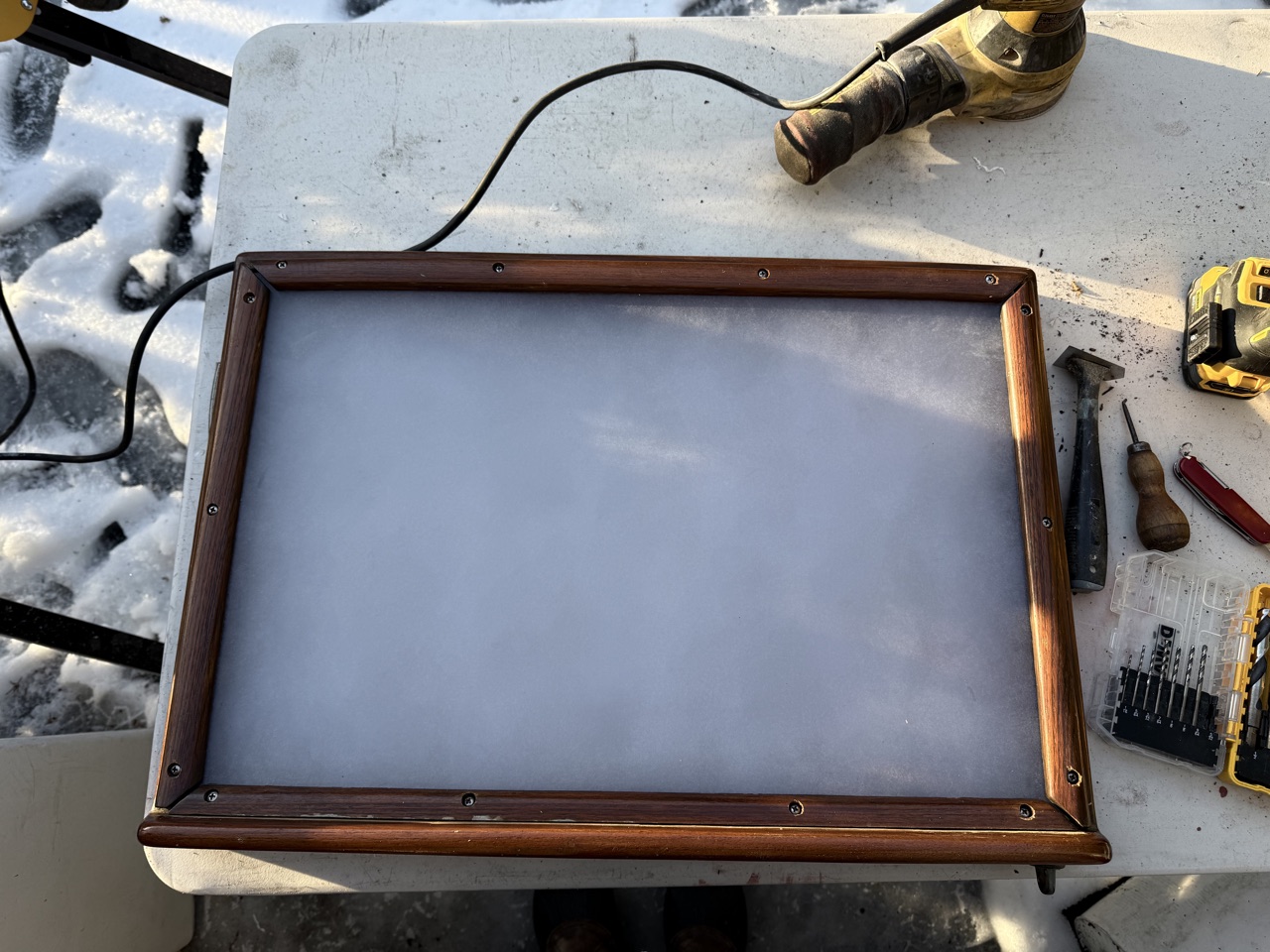 New polycarbonate panel dry-fitted in the teak hatch frame with screws positioned, before sealant