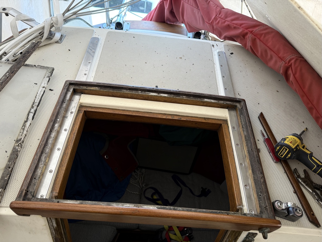 Looking down into the aft cabin opening with the hatch removed, showing the stainless track and accumulated grime