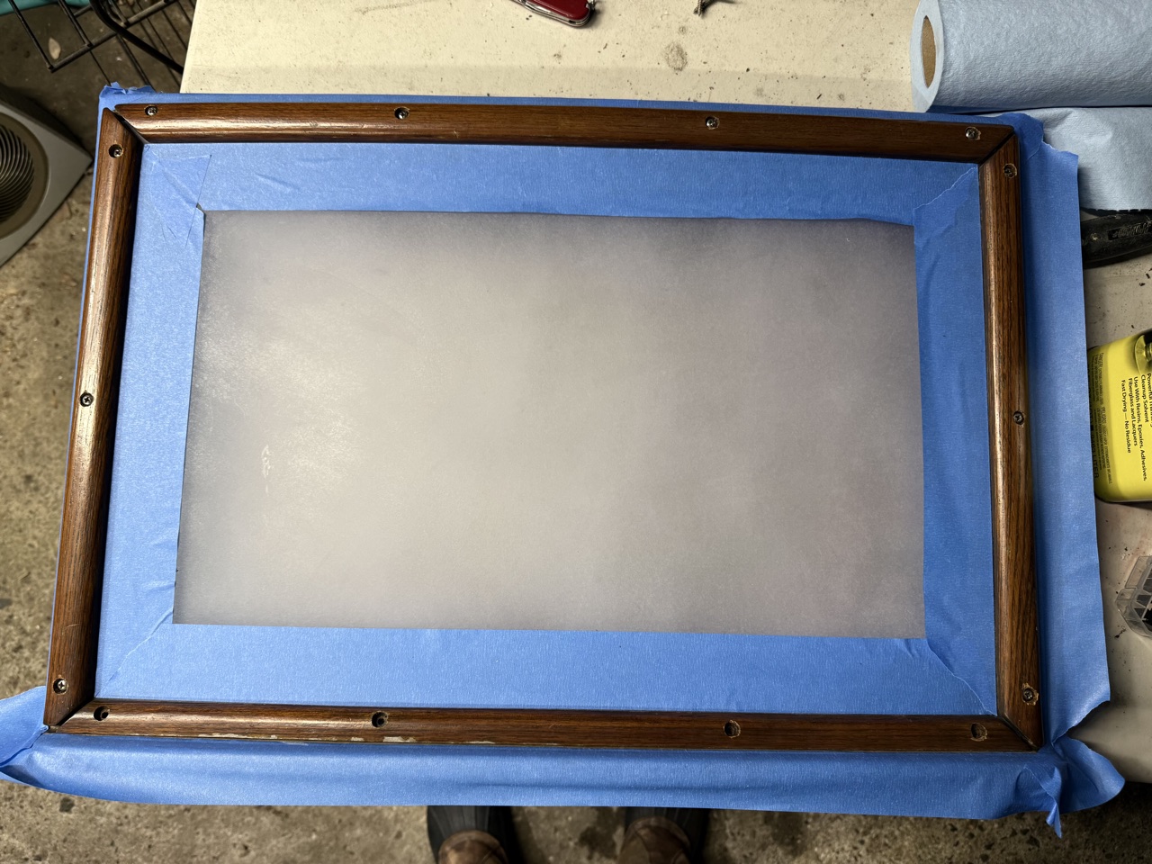 Aft cabin hatch panel masked with blue tape around the perimeter, ready for 4200 sealant application