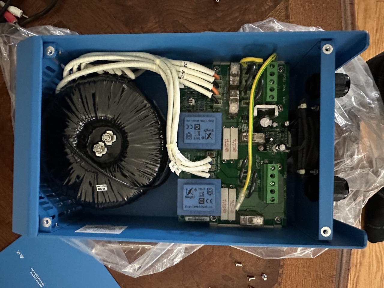 Inside the Victron 2000W Isolation Transformer with the case open, showing the toroid on the left and control board on the right with white wires in the original boost configuration